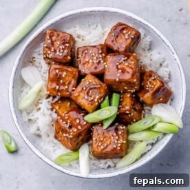 top view honey garlic tofu bites served over a bowl of rice