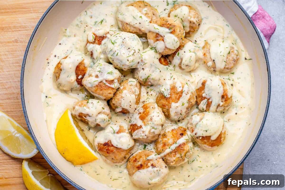 Chicken meatballs cooking in a creamy lemon sauce.