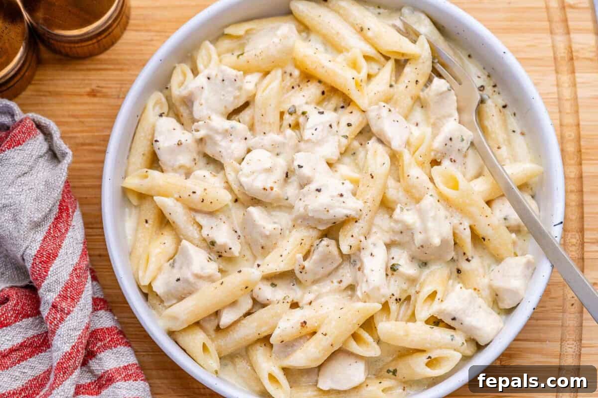 Chicken alfredo in a bowl with a spoon in it.