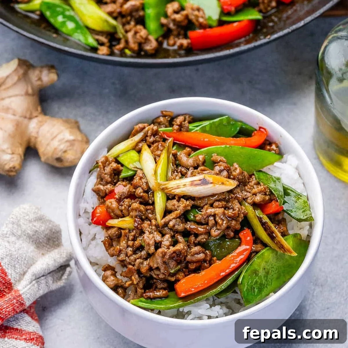 ground beef stir fry served over rice in a bowl.