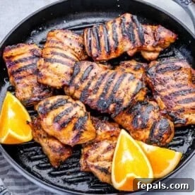 Weeknight Boneless Chicken Thigh Recipes 5 chicken thighs grilled in a grill pan with orange wedges.