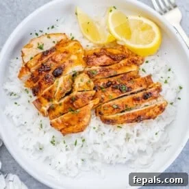 Weeknight Boneless Chicken Thigh Recipes 6 top view of a round white bowl with steamed white rice and sliced air-fried boneless chicken thighs