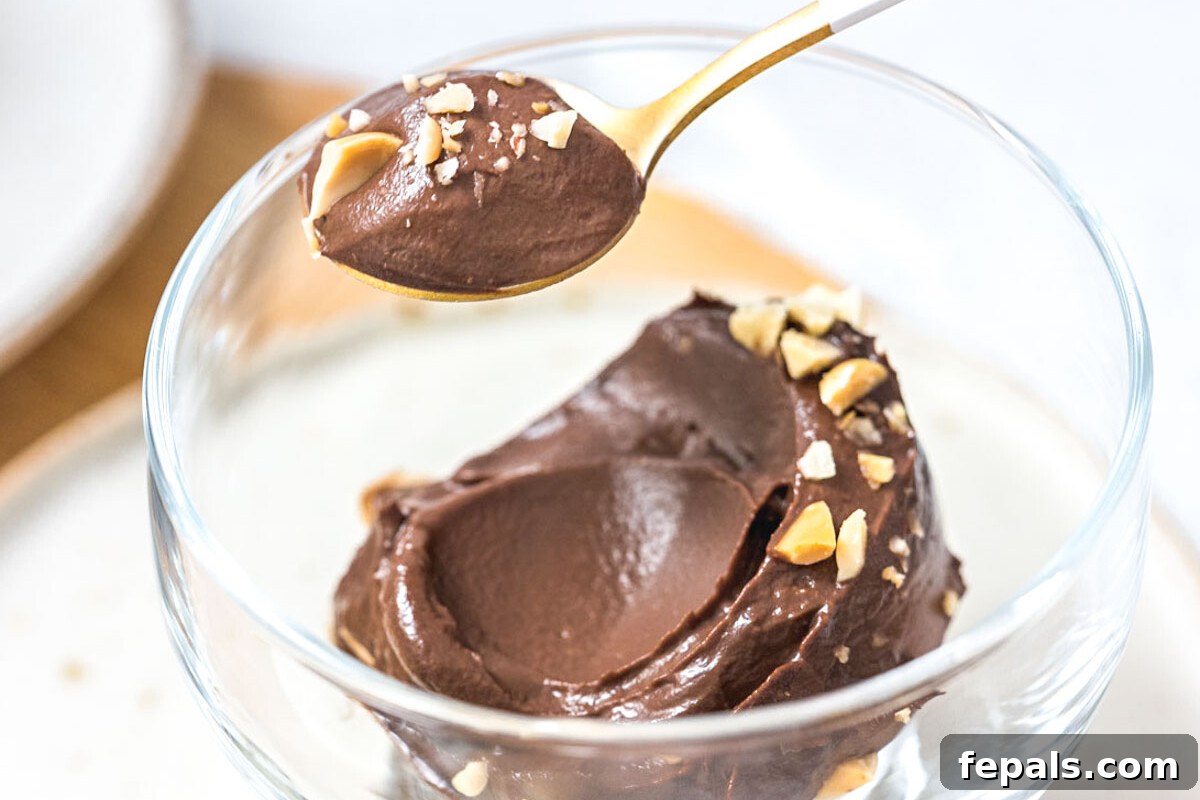 Using a spoon to take a serving of chocolate avocado ice cream.