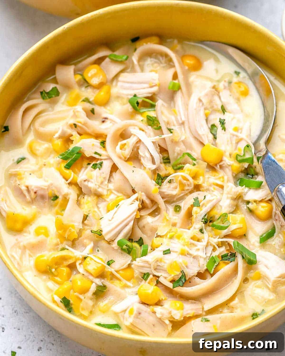 Creamy Rotisserie Chicken and Corn Soup 2 a bowl with a creamy looking chicken and corn soup with noodles.