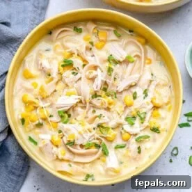Creamy Rotisserie Chicken and Corn Soup 5 a yellow round bowl filled with chicken corn soup made with noodles