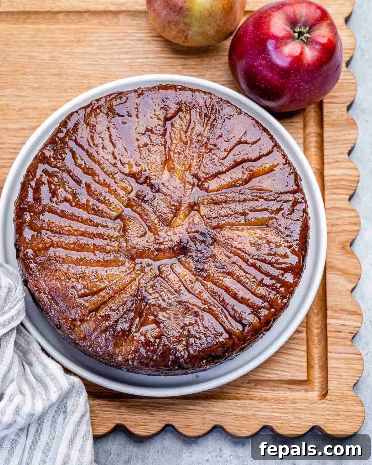 Apple Upside-Down Cake Recipe with Caramelized Apples 2 caked flipped over a plate on a cutting board.