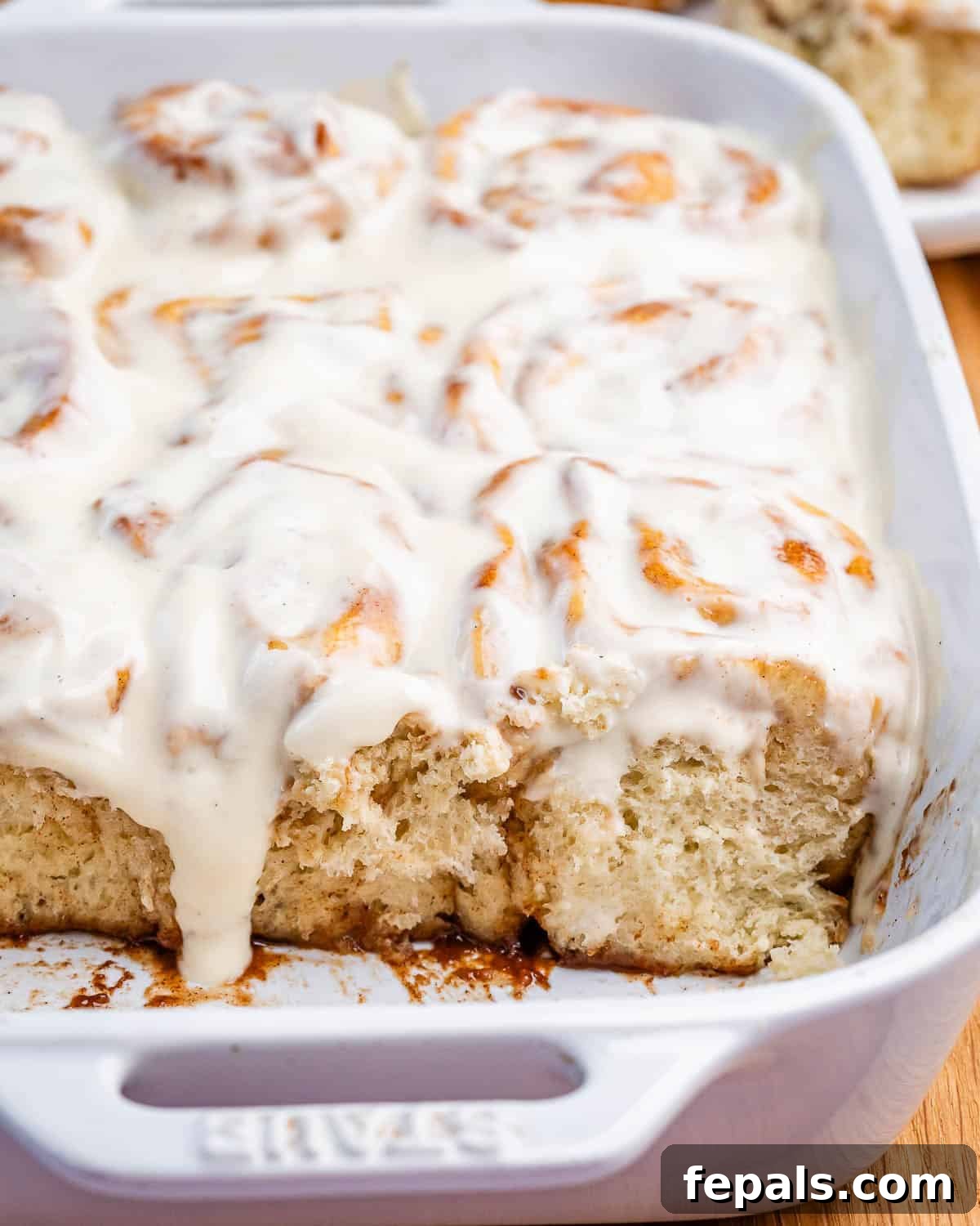 Greek Yogurt Cinnamon Rolls: Soft, Tangy, Homemade 8 Homemade cinnamon rolls with cream cheese glaze in a white baking dish.