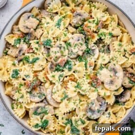 Vegetarian Pasta Recipes for Flavorful Weeknight Dinners 14 top view of mushroom and spinach pasta in an orange pan