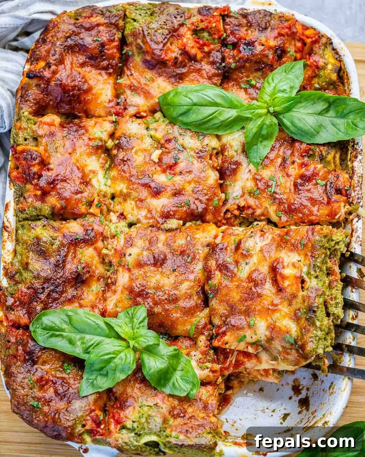 Creamy Chicken Lasagna with Cottage Cheese Recipe 2 A chicken lasagna in a white dish with a spatula lifting out a slice.