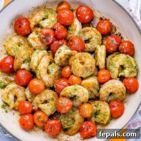 top view pesto shrimp sauteed with cherry tomatoes in a pan