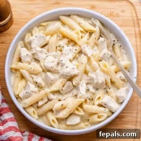 chicken alfredo with penne pasta served in a round white bowl.
