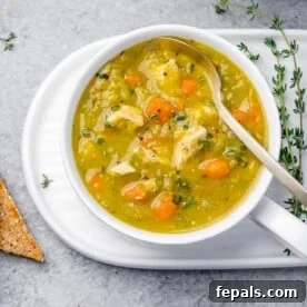 top view of a white round bowl of split pea soup with a spoon in the bowl on the right side
