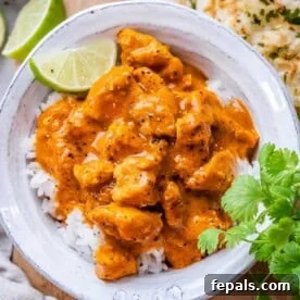 chicken curry over white rice in a bowl.